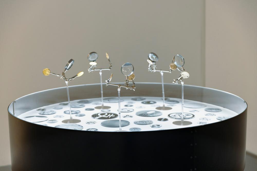 Musquiqui Chihying, The Culture Center, 2018 –2020, installation, light table, magnifying glass, zinc alloy coins, 100 × 120 cm, photo: Angelika Zinzow, © basis e.V.